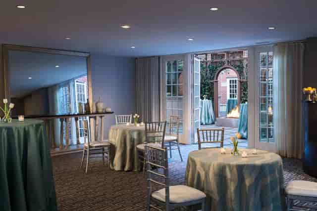 Elegant event space with round tables and chiavari chairs at Archer Hotel Alexandria.