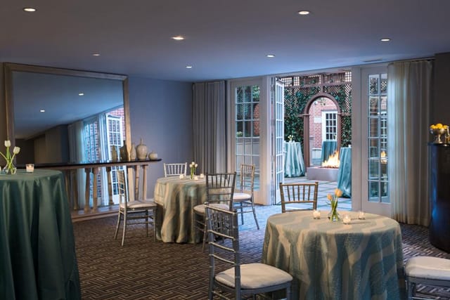 Elegant event space with round tables and chiavari chairs at Archer Hotel Alexandria.