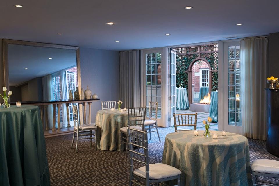 Elegant event space at Archer Hotel Alexandria with blue tablecloths and chiavari chairs.