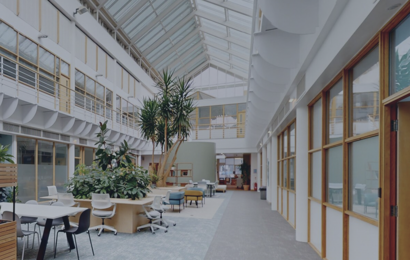 Modern atrium in Cambridge Innovation Parks, ideal for meetings and networking events. - Banner