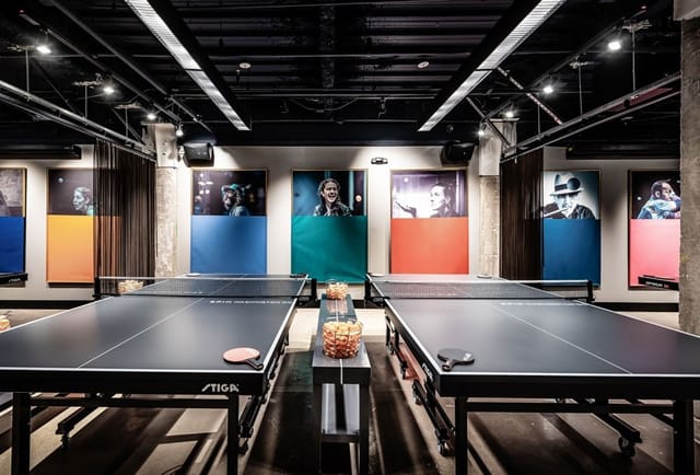 Modern lounge with ping pong tables for corporate events and team-building activities.