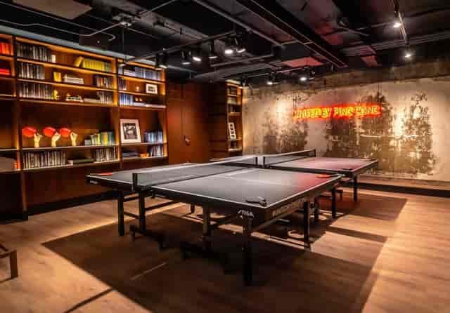 Modern sports bar with ping pong tables, ideal for team-building and casual events.
