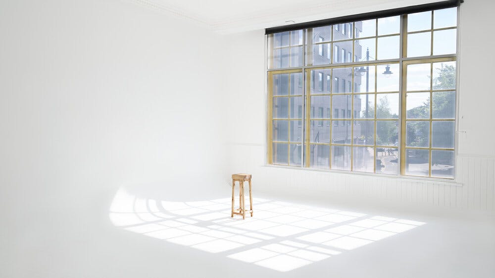 Bright minimalist event space with natural light, ideal for workshops and gatherings.