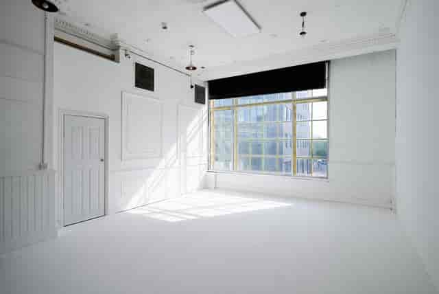 Bright minimalist event space with large window, perfect for meetings and workshops.