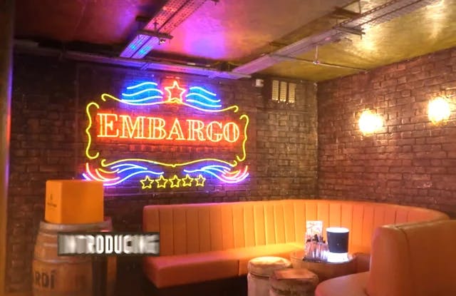 Cocktail bar Embargo Republica with neon sign, ideal for networking events and casual meetings.