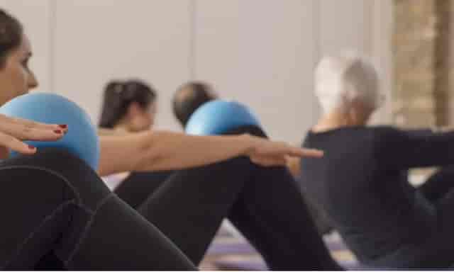 Group fitness class with exercise balls in triyoga Treatment Rooms for corporate wellness events.