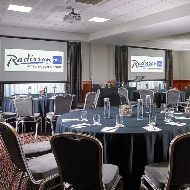 Meeting room at Radisson Blu Dublin Airport, featuring round tables for corporate events.