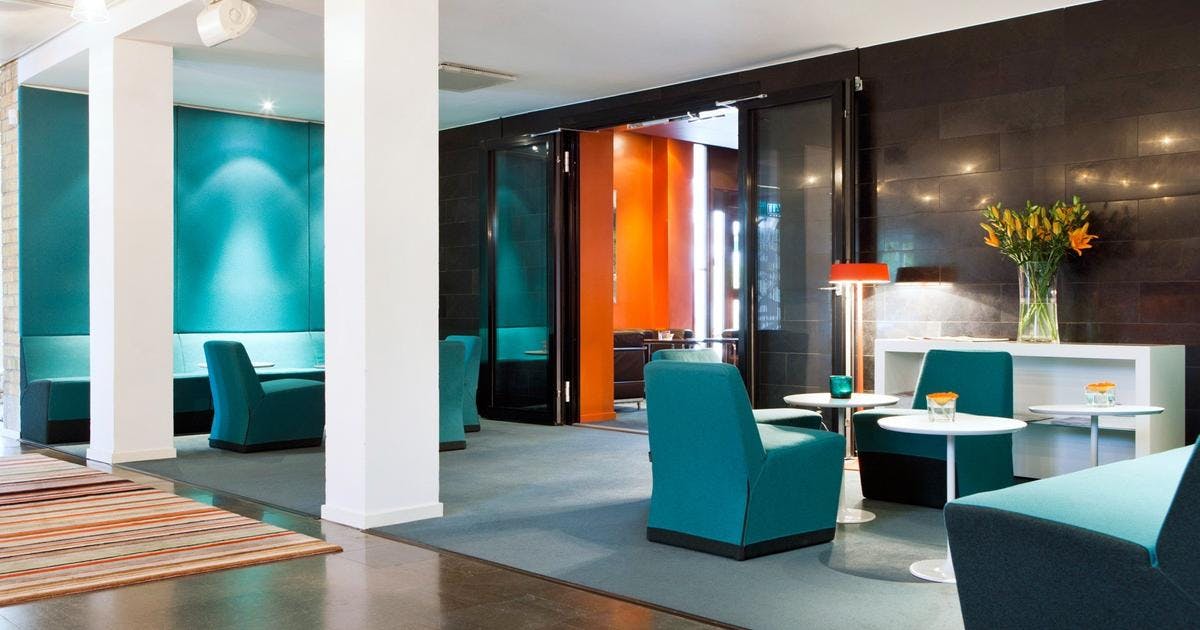 Modern meeting space at Elite Hotel Arcadia with teal accents, ideal for networking events.
