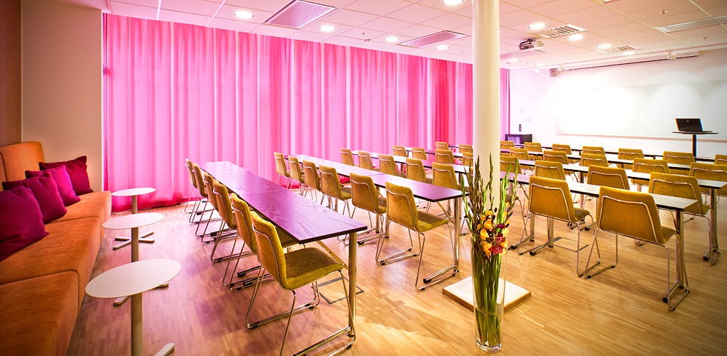 Modern meeting space with pink curtains, ideal for corporate events and workshops.