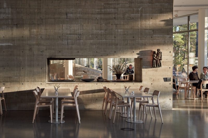 Modern event space at Bådan Café with concrete wall, ideal for meetings and gatherings.