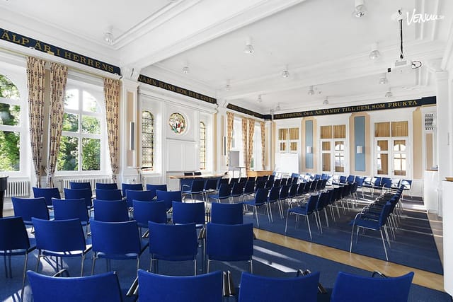 Event space at Ersta Conference with blue chairs, ideal for meetings and workshops.