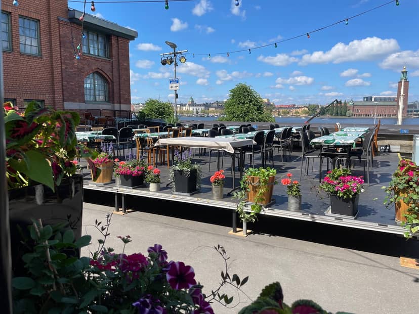 Charming outdoor event space at Münchenbryggeriet with vibrant flowers, ideal for gatherings.