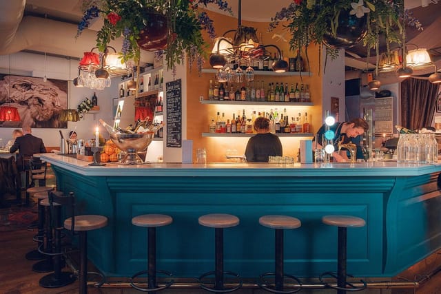 Vibrant bar area in Aubergine restaurant, perfect for networking events and social gatherings.