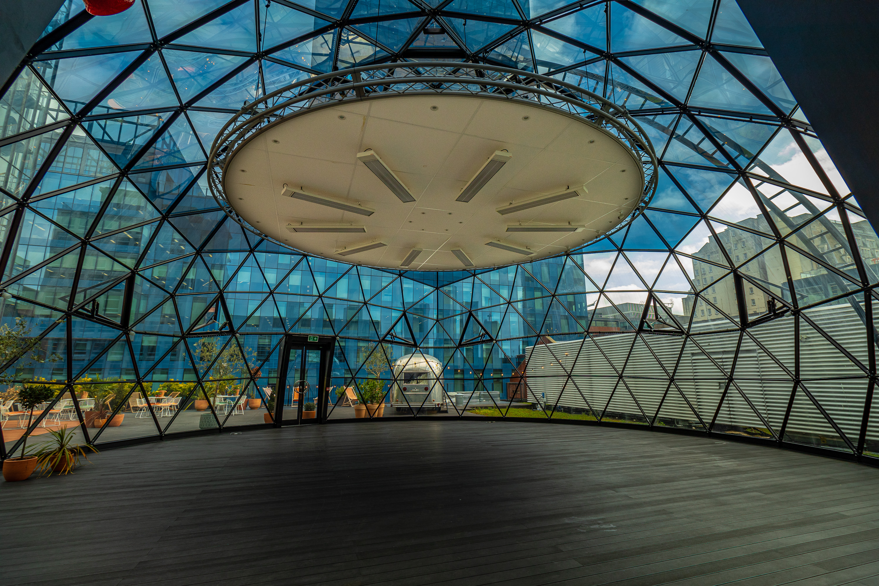 Modern glass-enclosed event space with geometric design, ideal for corporate meetings and gatherings. - Banner