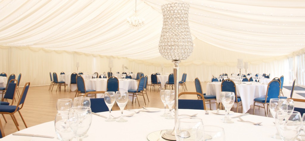 Elegant Pavilion at Quendon Hall with round tables, ideal for weddings and formal events.