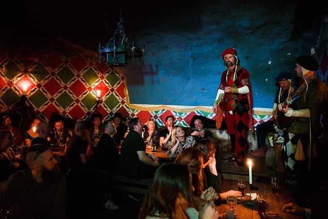 "Vibrant medieval restaurant with performers engaging guests in a themed event setting."