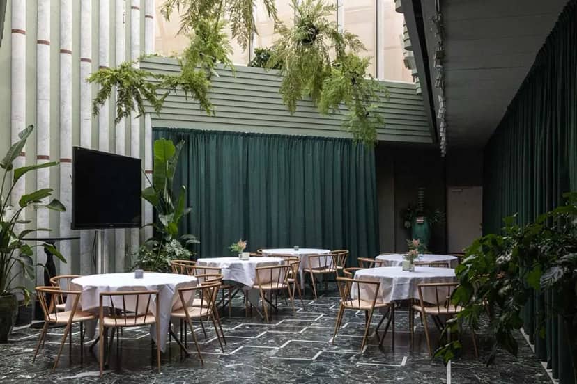Elegant event space in Ljusgården, Berns with round tables and lush greenery.