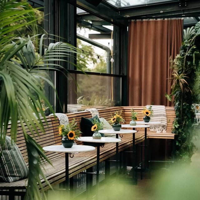 Stylish meeting space in Bern with cozy seating and vibrant sunflowers for events.