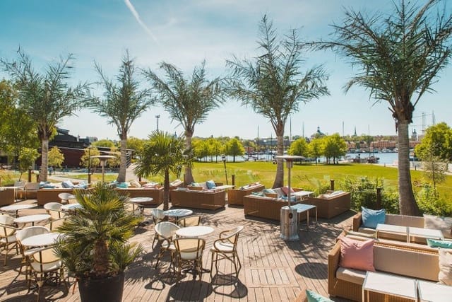 Vibrant outdoor event space at Josefina Stockholm with lush greenery and waterfront view.