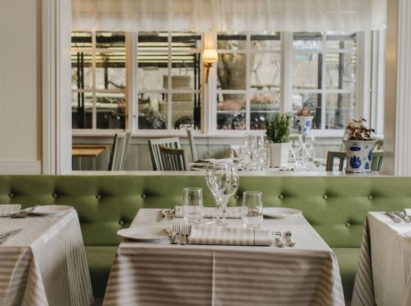 Elegant Swedish restaurant setting with green banquette, ideal for private dinners and networking.
