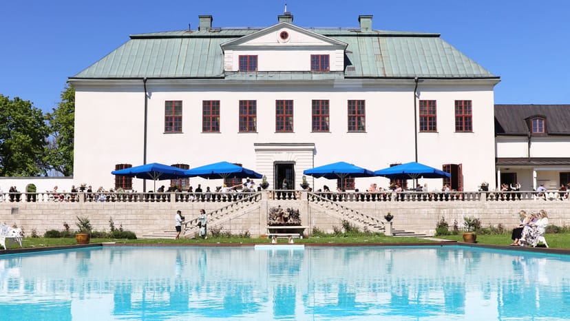 Elegant Häringe Slott restaurant with blue umbrellas, perfect for summer weddings and events.
