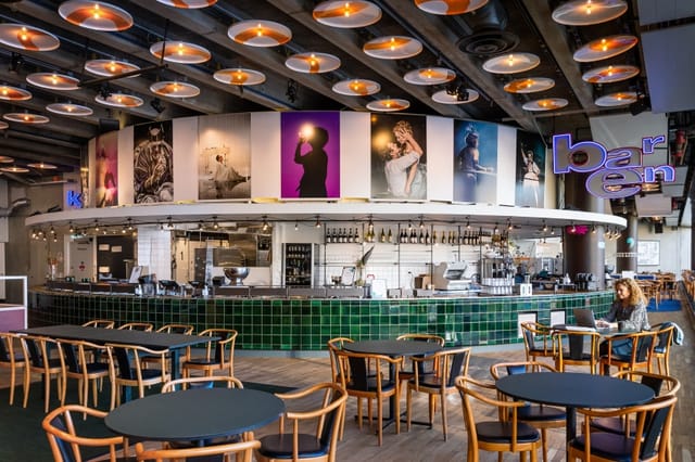 Modern event space with stylish bar, ideal for social gatherings and workshops.