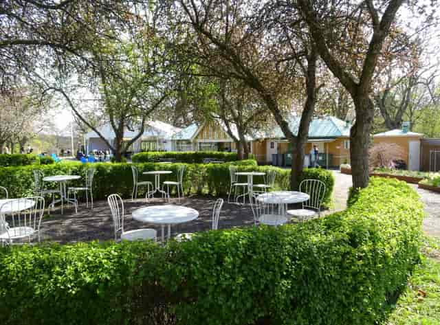 Charming outdoor meeting space at Rosendals Wärdshus with white tables for networking events.