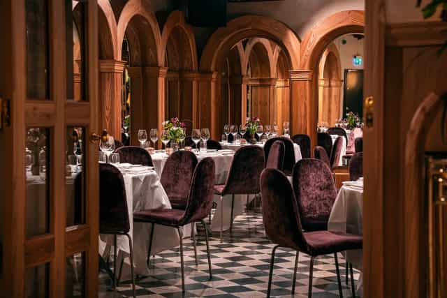 Elegant dining space at La Voûte, featuring wooden arches for upscale events.