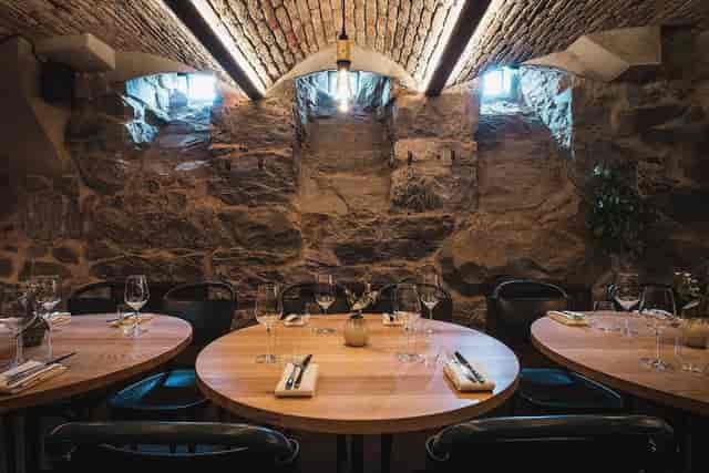 Rustic event space with stone walls and modern lighting for intimate gatherings.