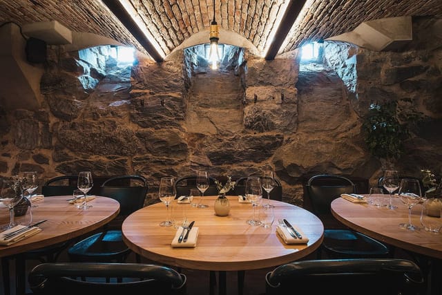 Rustic event space with stone walls and modern lighting for intimate gatherings.
