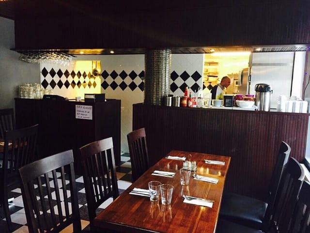 Cozy restaurant dining space with polished wooden table, ideal for networking lunches.