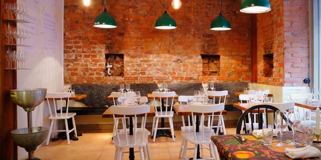 Cozy restaurant with exposed brick walls, perfect for intimate gatherings and meetings.