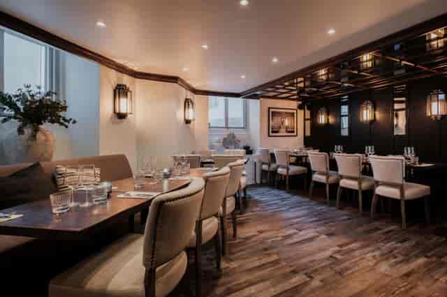 Sophisticated dining room with warm lighting for intimate corporate events and networking dinners.