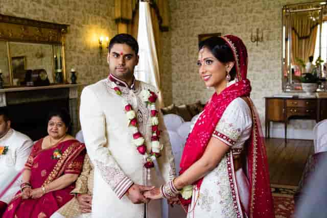 Elegant wedding ceremony in Drawing Room, Parklands Quendon Hall with classic decor.