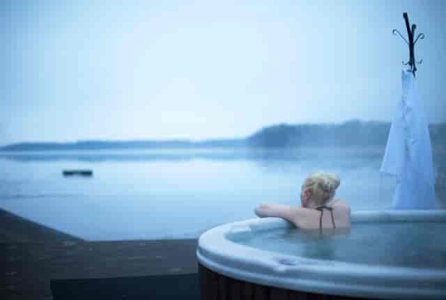 Hot tub by tranquil lake at Rånäs Slott, perfect for wellness retreats and team-building.