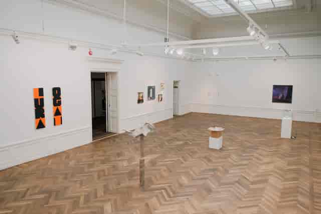 Spacious art gallery with wooden flooring, ideal for exhibitions and corporate events.
