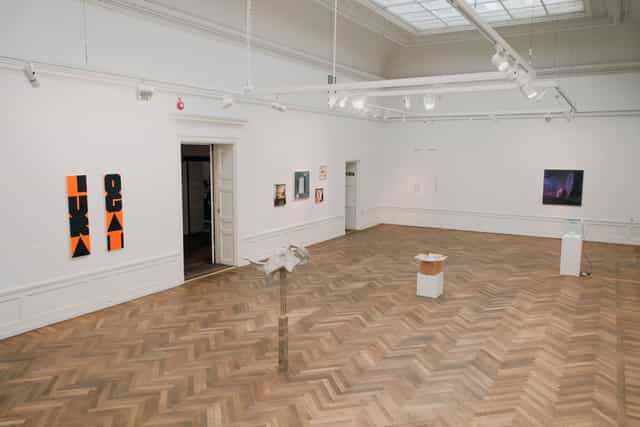 Spacious art gallery with wooden flooring, ideal for exhibitions and corporate events.