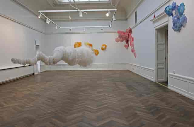 Colorful cloud-like sculptures in a spacious art gallery for creative events.