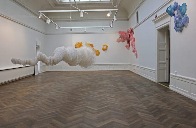 Colorful cloud-like sculptures in a spacious art gallery for creative events.