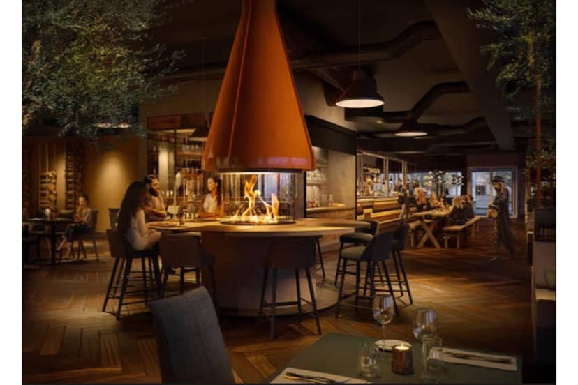 Modern restaurant with central fireplace, ideal for networking events and casual dinners.