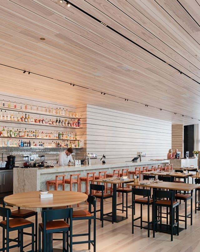 Modern bar area in Nordic Light Hotel with marble countertop, ideal for networking events.