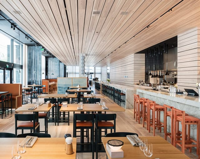 Modern restaurant in Nordic Light Hotel with wooden accents, perfect for corporate events.