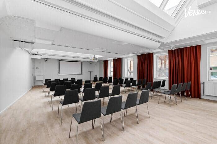 Versatile meeting space with black chairs, ideal for workshops and presentations in Stockholm.