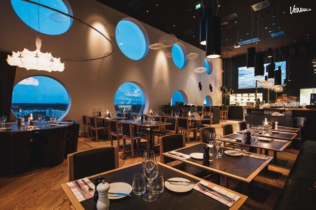 Modern restaurant with circular windows, ideal for dinners and corporate events.