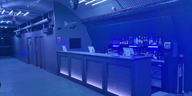 Modern bar area in N7 London, featuring ambient blue lighting for events and gatherings.
