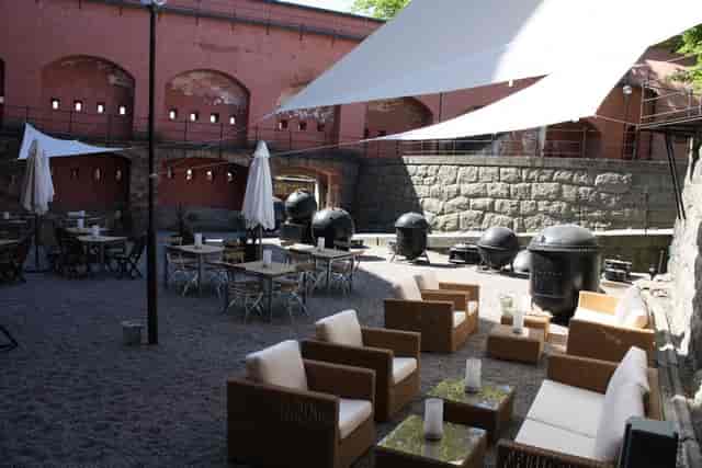 Stylish outdoor event space at Restaurant Pansarbatteriet with modern seating and grills.