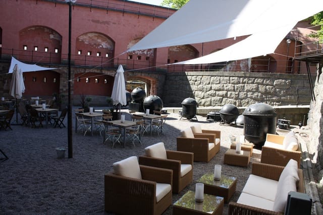 Stylish outdoor event space at Restaurant Pansarbatteriet with modern seating and grills.