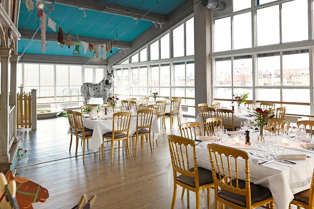Elegant dining setup at Circus restaurant, featuring floral centerpieces and whimsical horse sculpture.