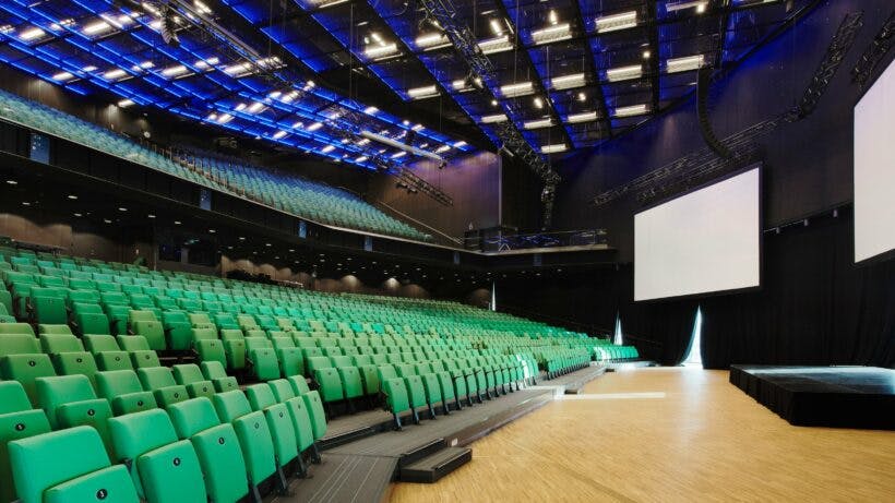 Modern meeting room in Stockholm with tiered green seating for conferences and seminars.