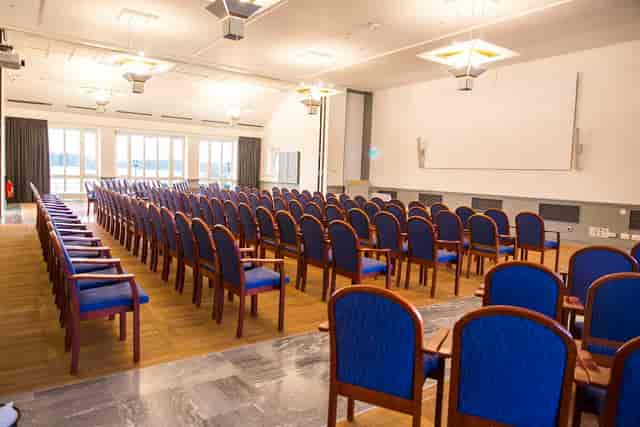 Spacious conference room with blue chairs for presentations at Grand Hotel Saltsjöbaden.